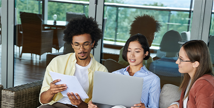 three people looking at a laptop